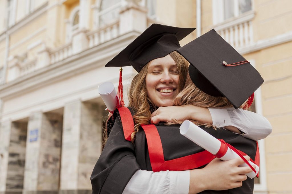 Happy graduate hugging friend